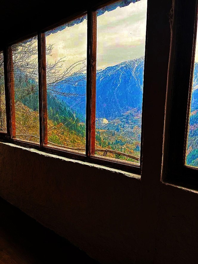 Parvati's Lap Hostel and Villa parvati valley, kasol, Himalayas - Large dormitory featuring panoramic mountain views through wide windows. This 14-bed stone room is ideal for large groups, trekkers, and backpackers traveling together in Parvati Valley.