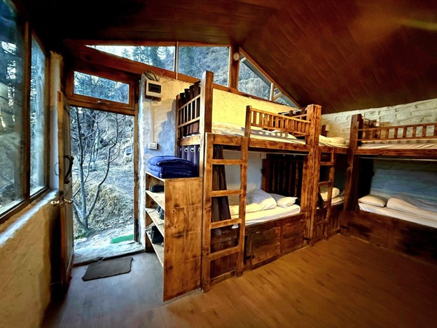 Parvati's Lap Hostel and Villa parvati valley, kasol, Himalayas - Spacious interior with solid wooden bunk beds and sturdy stone-textured walls. Designed to accommodate trekking groups visiting Kheerganga and Tosh.